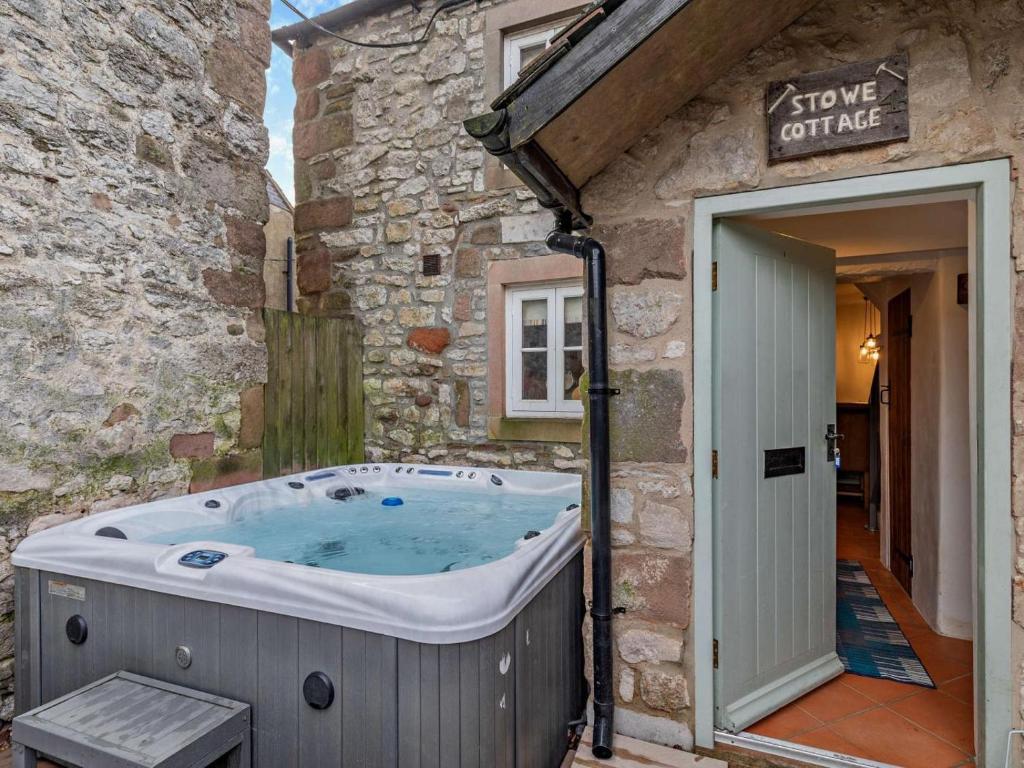 a hot tub outside of a stone building at 1 Bed in Matlock oc-75400 in Middleton