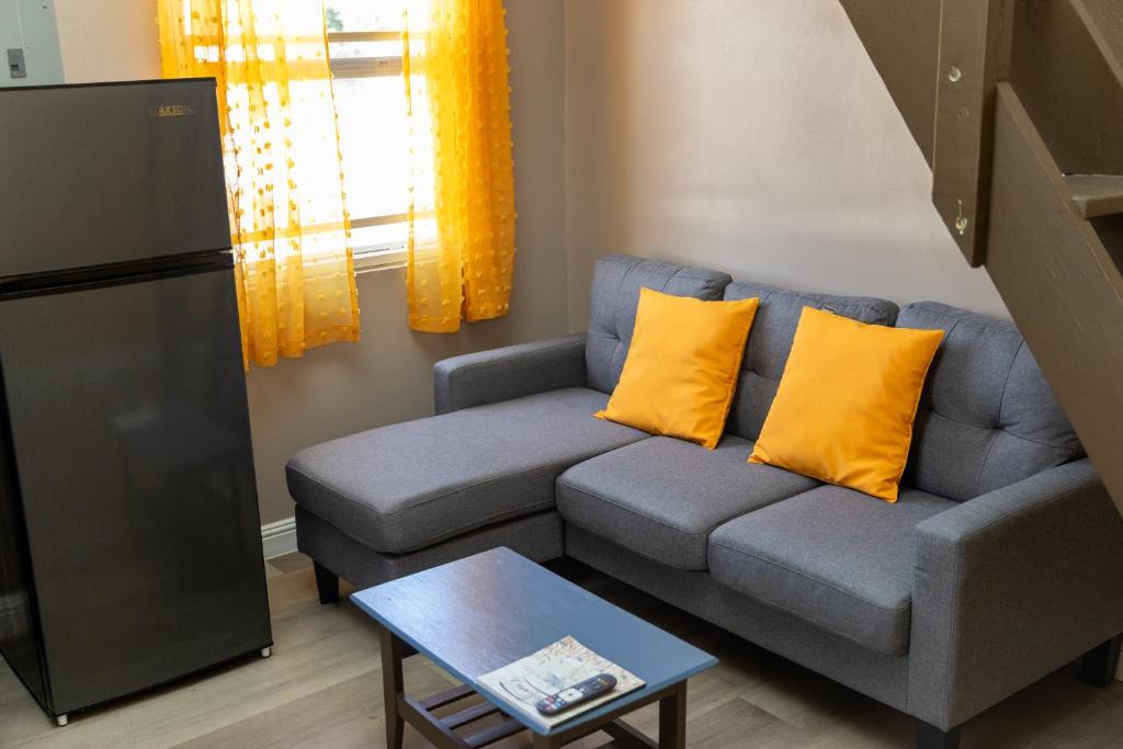 ein Wohnzimmer mit blauem Sofa und gelben Kissen in der Unterkunft Comfi Spaces in Canaan