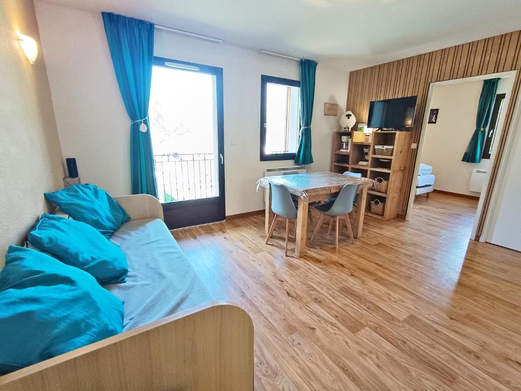 a living room with a bed and a table at Lia, T3, au calme, parking, internet in Luchon