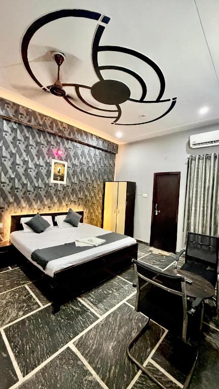 a bedroom with a large bed and a chandelier at Hotel Madhav Inn in Lucknow