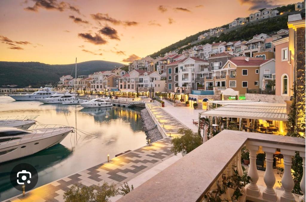 a town with boats in a marina at sunset at Lux Studio Lustica Bay and Car in Luštica