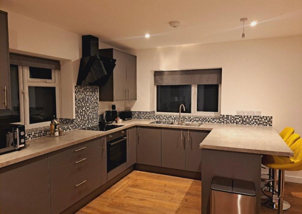 a kitchen with gray cabinets and a counter top at Yew Tree Retreat- Sunset Suite in Newbury