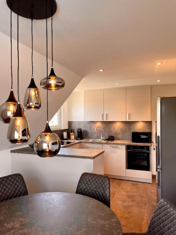 a kitchen with white cabinets and a table with chairs at Deluxe Apartment in Jettingen-Scheppach