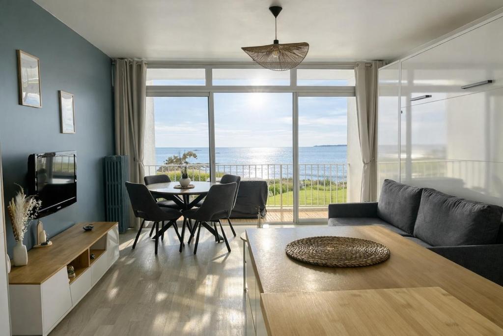 a living room with a couch and a table at Studio cosy avec terrasse, vue mer in Quiberon