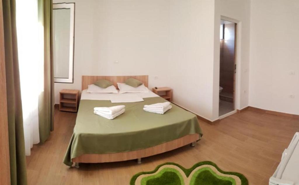 a bedroom with a bed with a green bedspread at Casa Enka in Tuzla