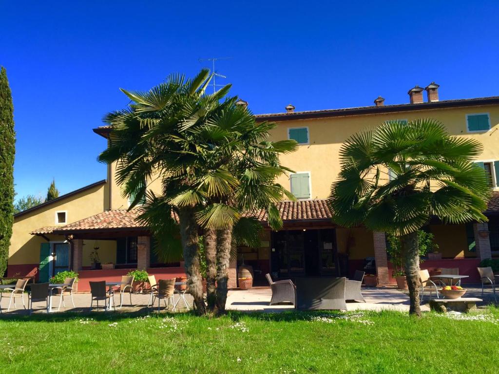 two palm trees in front of a building at Agriturismo Le Fornase in Castelnuovo del Garda