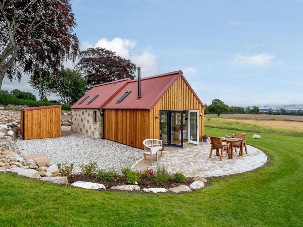 a building with a red roof and a table at 1 Bed in Alness oc-83888 in Alness