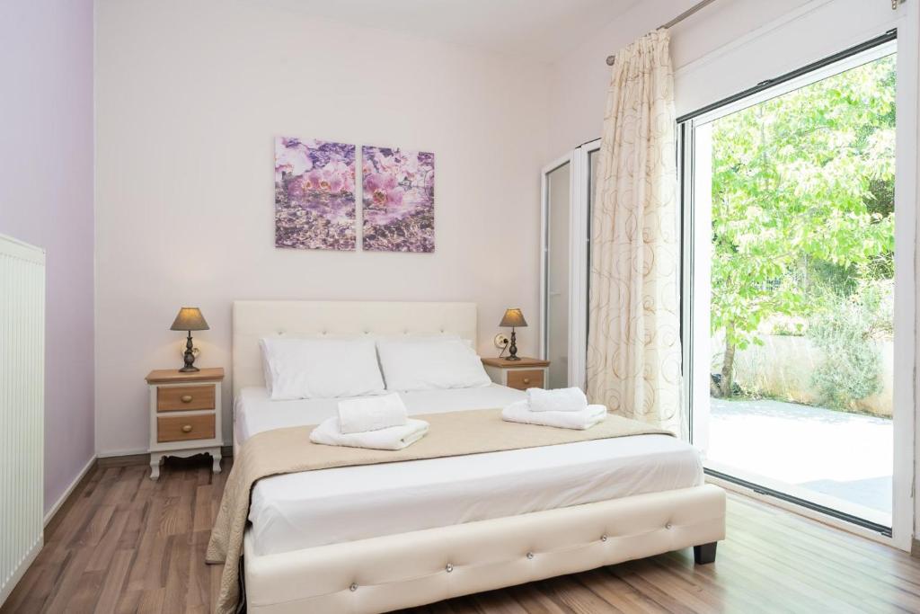 a bedroom with a bed and a large window at Orchid Garden Apartment in Sami