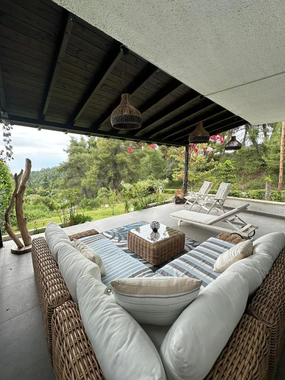a covered patio with couches and a table and chairs at 26 Villa Katerina, Elani in Elani