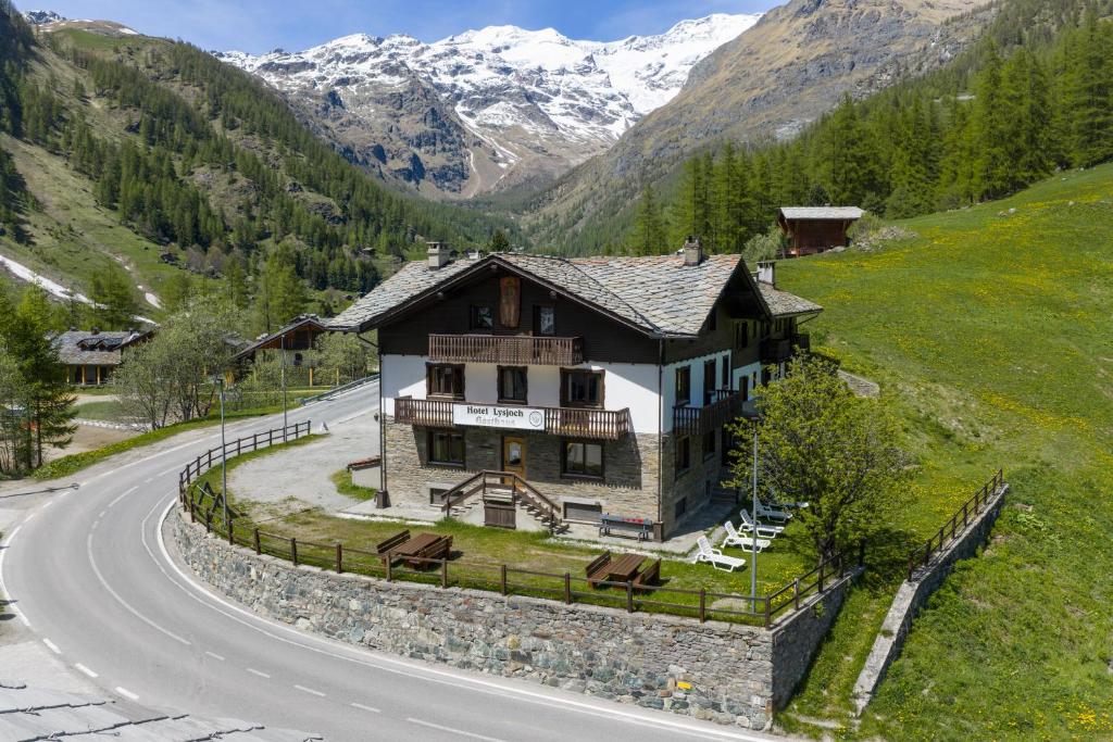 a house on a hill next to a road at Locanda del Lysjoch in Gressoney-la-Trinité