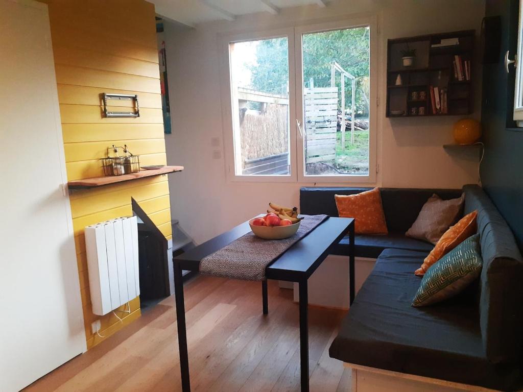 a living room with a couch and a table at Appartement du Fournil in Bréal-sous-Montfort