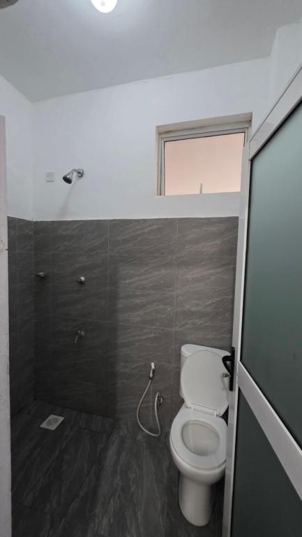 a small bathroom with a toilet and a window at TINTIN HOMES Mtwapa in Mtwapa