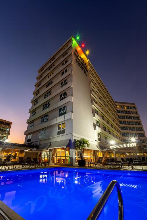 a hotel with a swimming pool in front of a building at Plaza Blumenau Hotel - Próximo Curt Hering, Via Gastronômica in Blumenau