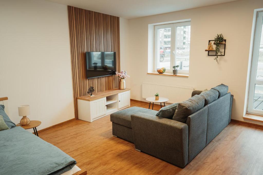 a living room with a couch and a tv at Apartmány u Jeníka in Děčín