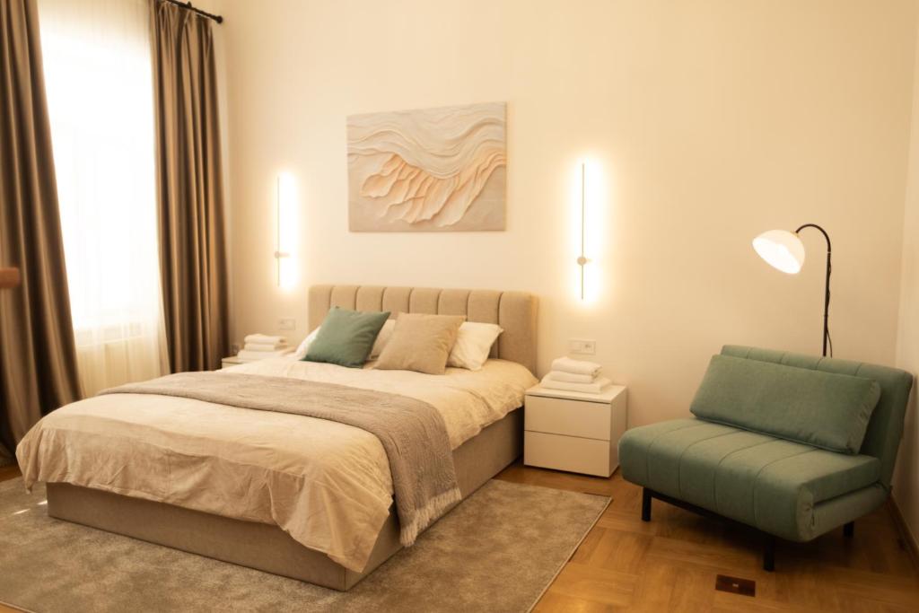a bedroom with a bed and a chair at Central Apartment Chortkiv in Chortkiv