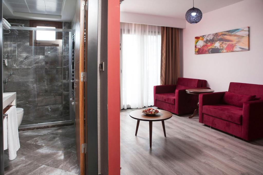 a living room with a red couch and a table at Buca Residence Hotel in İzmir