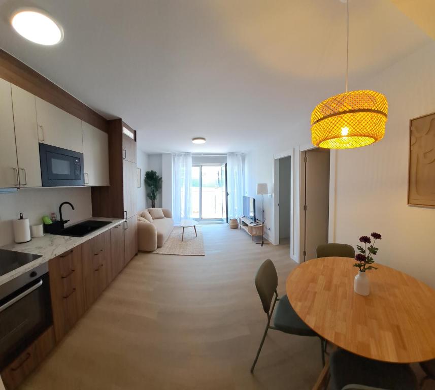 a kitchen and living room with a table and a dining room at Costa Canido II in Malpica