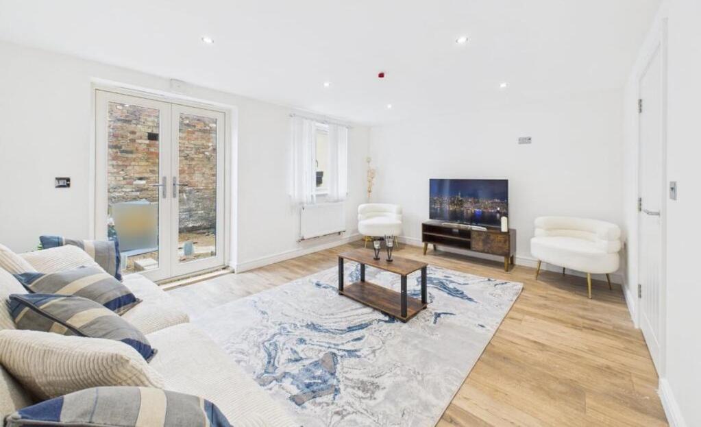 a living room with a couch and a tv at Charming Wootton in Hail Weston