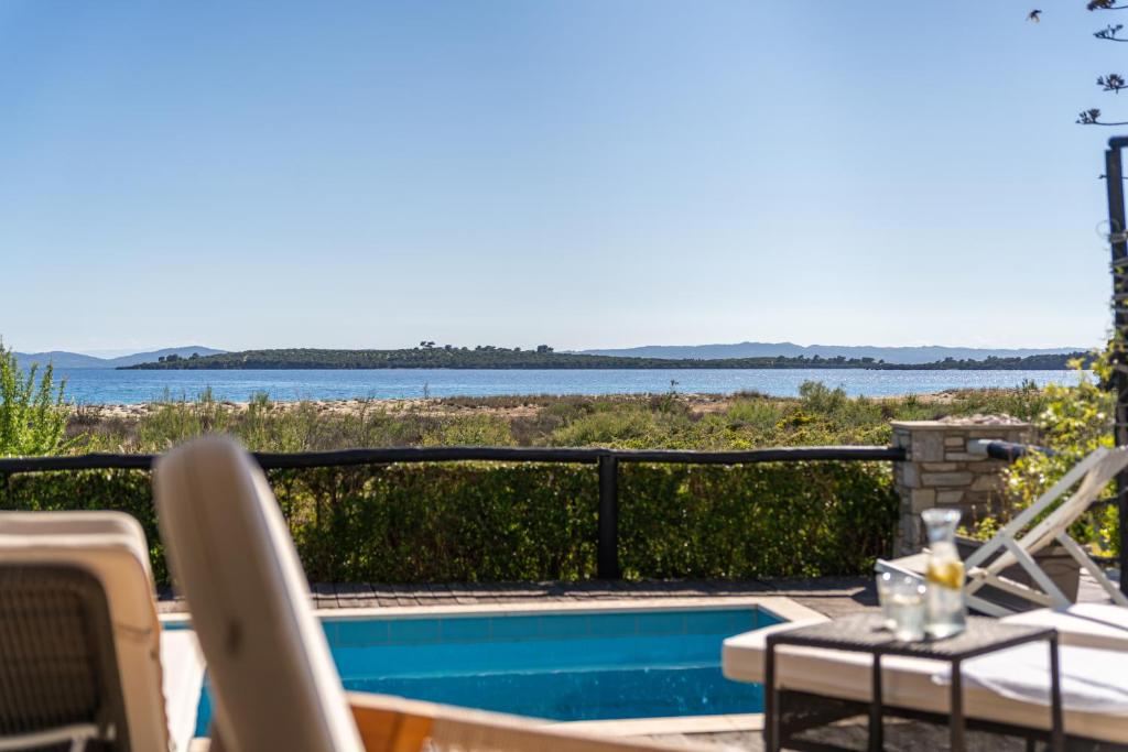 a patio with a pool and a view of the water at Villa Malvina in Neos Marmaras