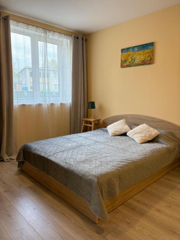 a bedroom with a bed and a large window at Butas pačiame miesto centre in Telšiai