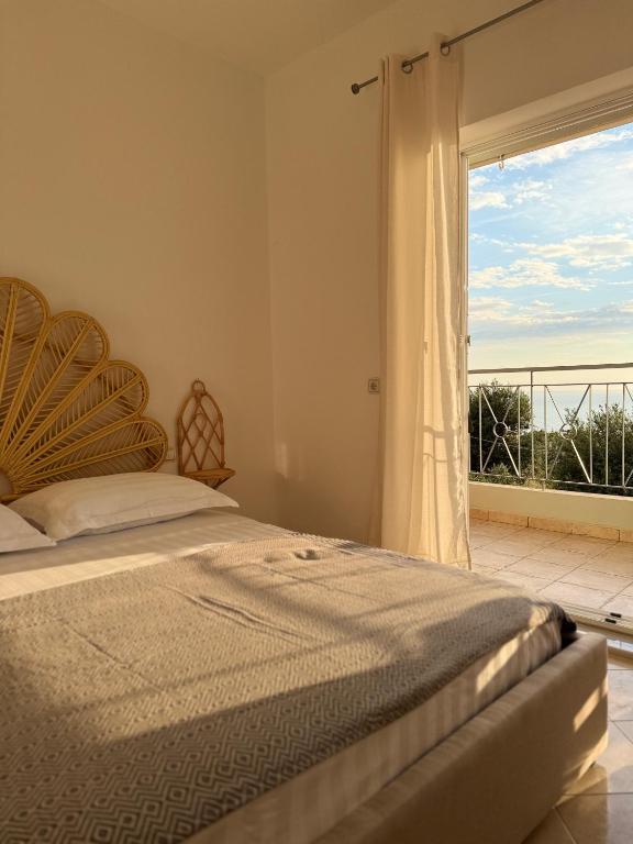 a bedroom with a bed and a large window at Casa Boha Garden in Dhërmi