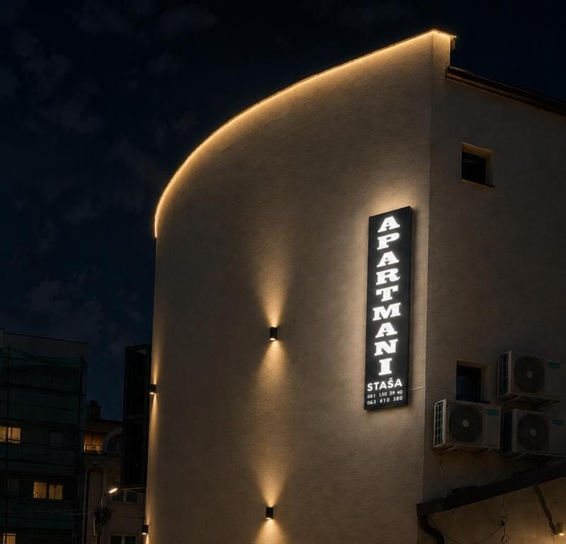 a sign on the side of a building at night at Staša Apartmani in Novi Pazar