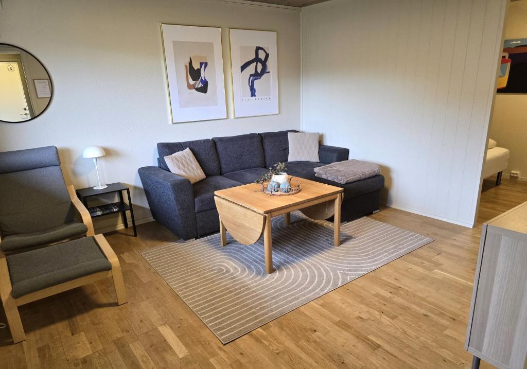 a living room with a blue couch and a table at Central apartment in Tromsø