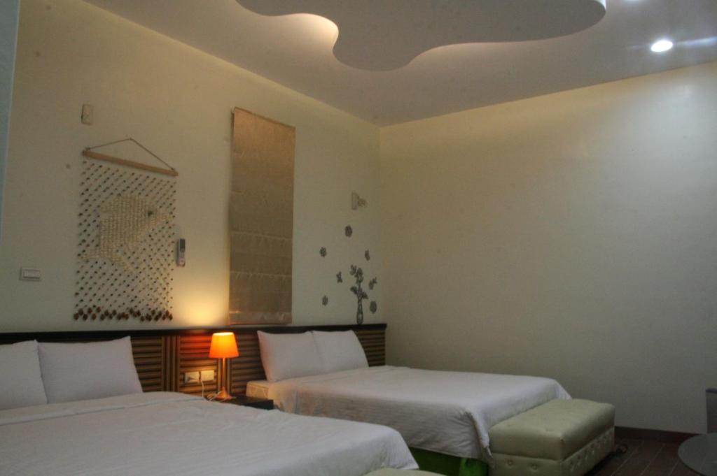 a hotel room with two beds and a ceiling at See Your Dreams B&amp;B in Magong