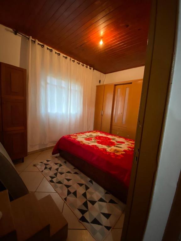 a small bedroom with a red bed in a room at Recanto Vieira in Lages