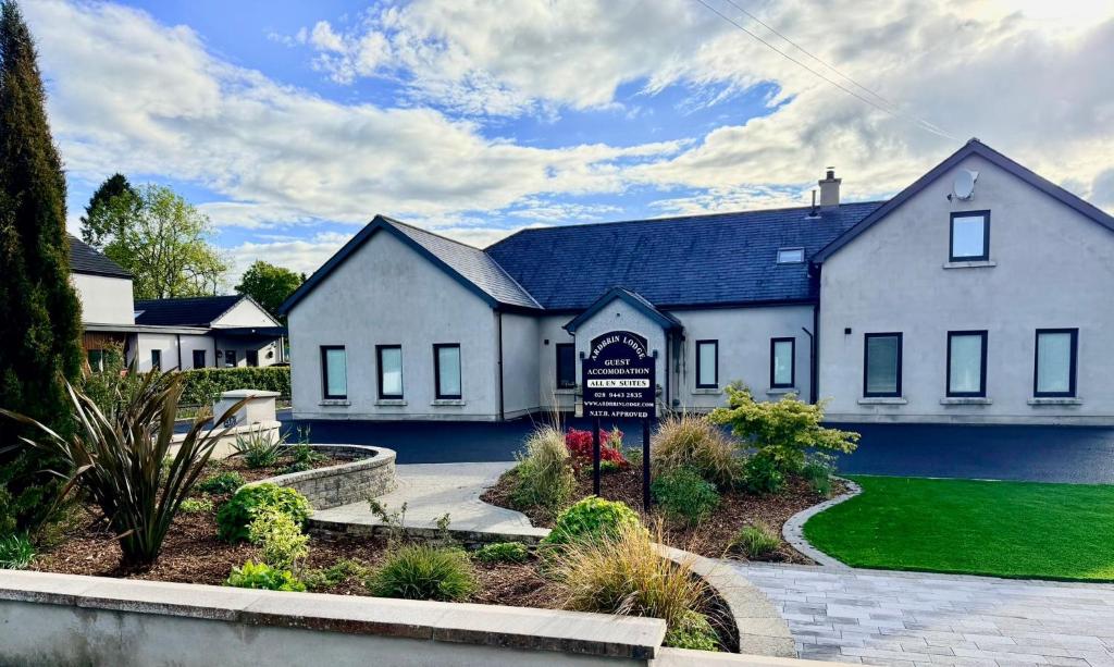 a large white house with a sign in front of it at Ardbrin Lodge Guest Accommodation in Dunadry