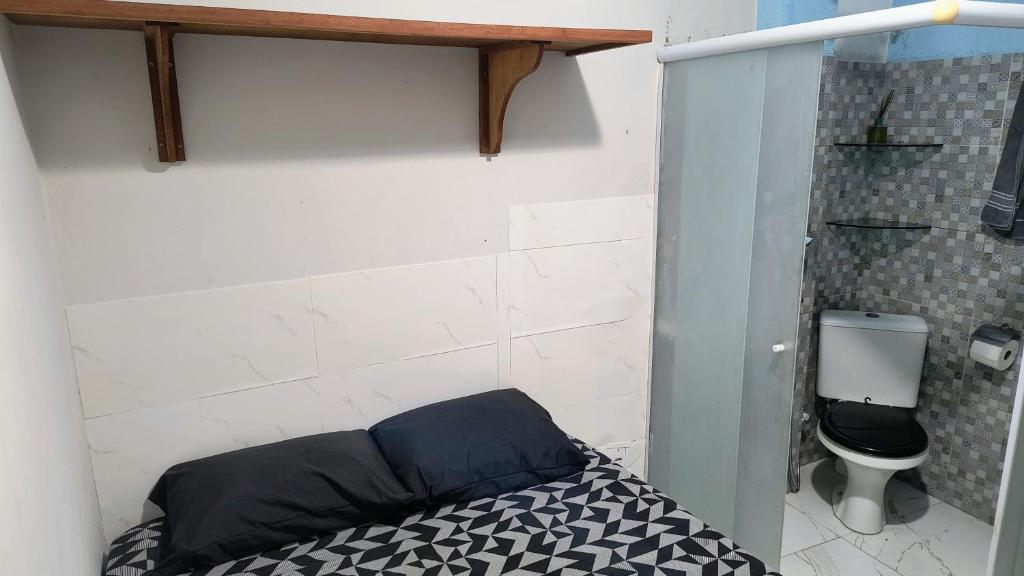 a small room with a bed and a toilet at Pousada Solar da Costa 1908 quarto com banheiro in Serra