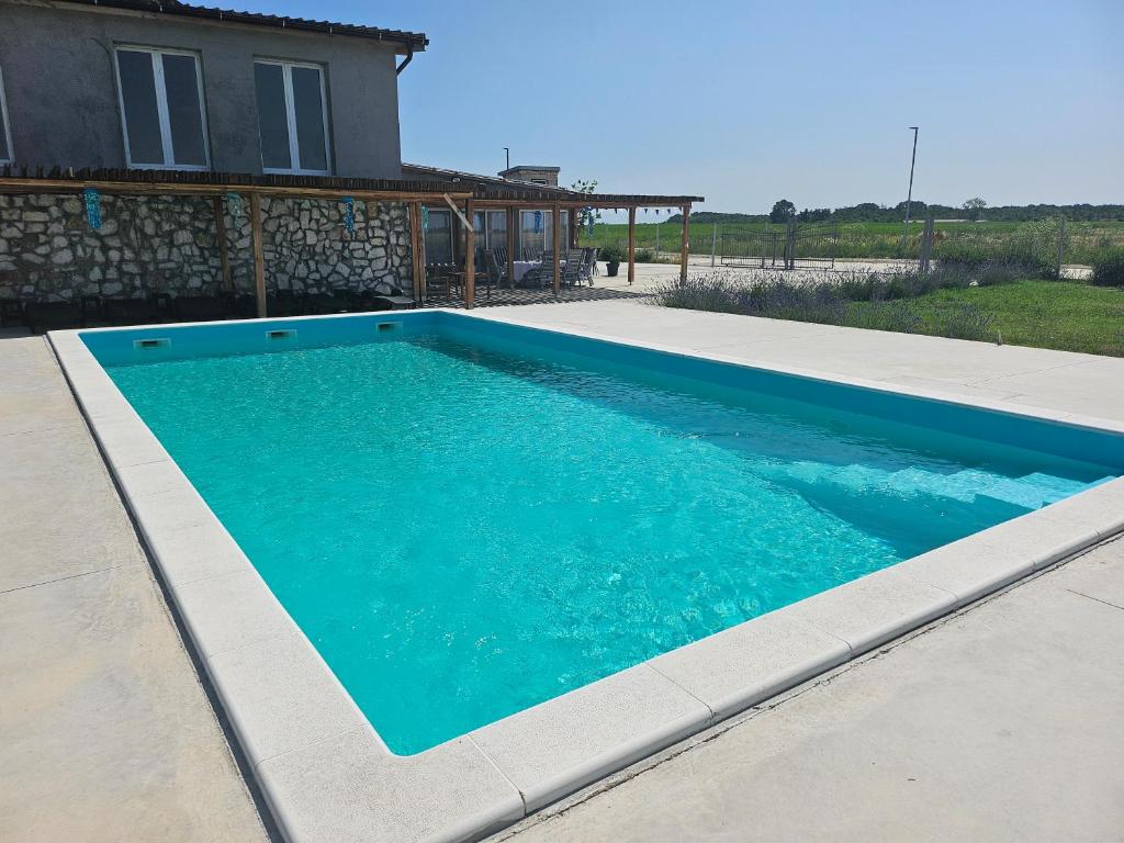 a swimming pool in front of a house at Pepi Sobe in Čepin