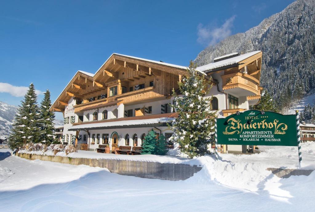 a large building with a sign in the snow at Apparthotel Thalerhof in Mayrhofen