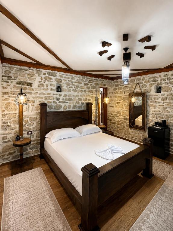 a bedroom with a bed and a brick wall at Forest House in Berat