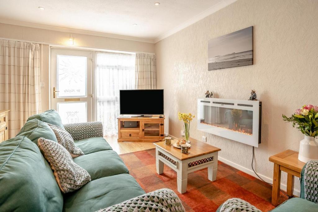 a living room with a green couch and a television at 2 Bed in Mumbles oc-hh505 in The Mumbles