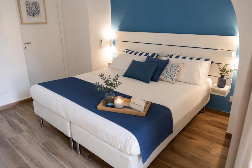 a bedroom with a large white bed with a tray on it at Harmonia Rooms by Italy Home Experience in Civitavecchia