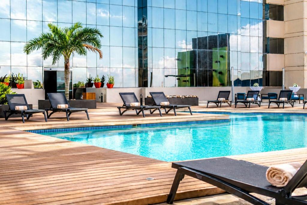 a swimming pool with lounge chairs and a building at Hyatt Regency Merida in Mérida