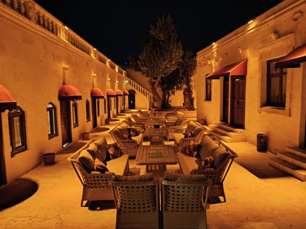 a row of tables and chairs on a courtyard at night at Aslan Guest House in Urfa