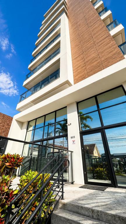 a building with glass doors and a tall building at MaxLoft - Studio Moderno in Joinville