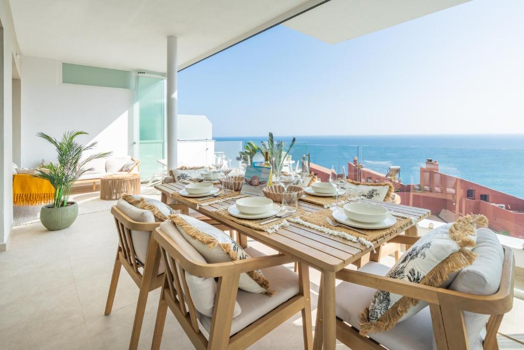 a dining room with a table and a view of the ocean at Bayview Hills Apartamento Andaluz in Torrox