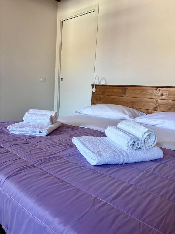 two stacks of towels sitting on a purple bed at Affittacamere Ca' Vecia in Riccò del Golfo di Spezia