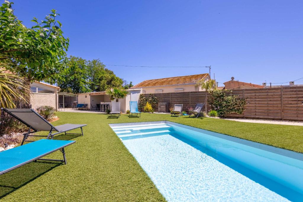 a backyard with a swimming pool and a house at Ensemble Villa et Studio Piscine Proche Plage in Valras-Plage