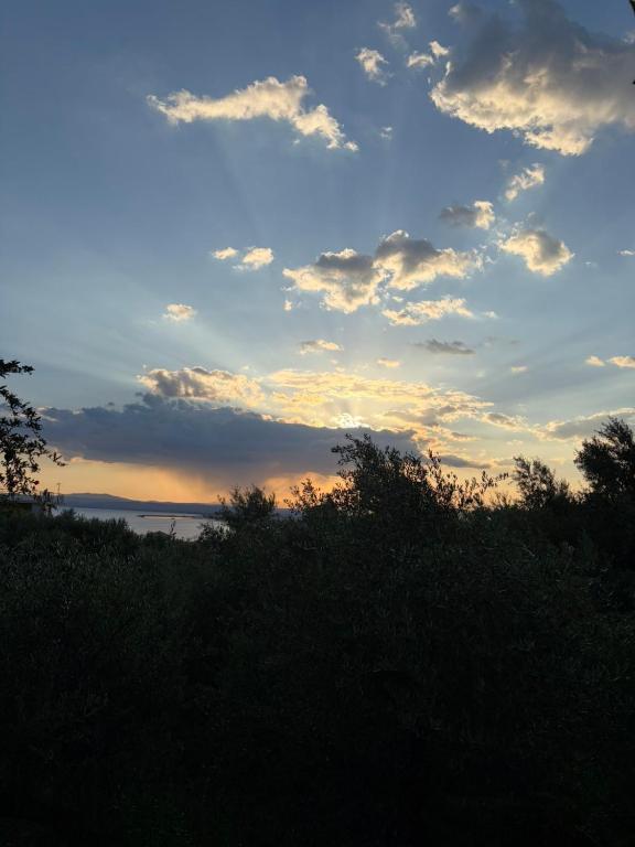 a sunset over the water with clouds in the sky at Verga Olive Grove Studio in Kalamata