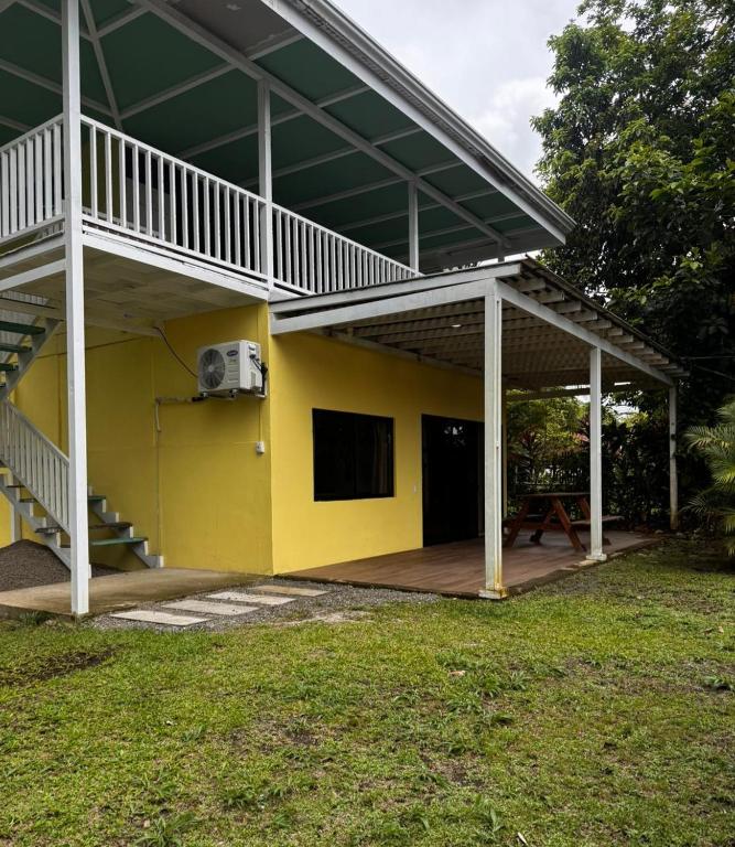 a yellow house with a balcony and a patio at Casa Melda Walk to the Beach & Gandoca-ManzanillO in Manzanillo