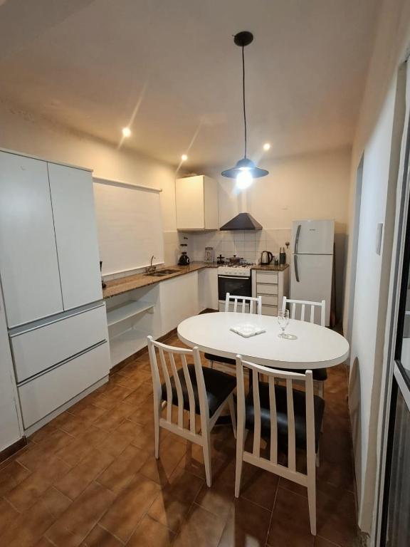 a kitchen with a white table and chairs in it at Departamento Abu Dolly in La Plata