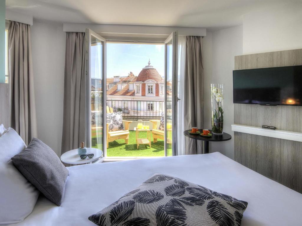 a hotel room with a bed and a large window at Ibis Styles Nice Centre Gare in Nice