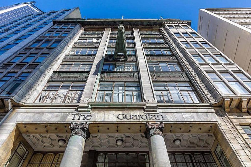 a tall building with a sign on the front of it at Art Deco Chic on Queen in Auckland