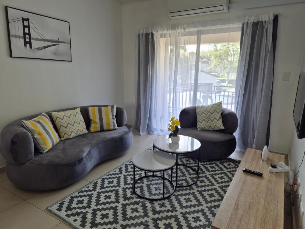 a living room with two couches and a table at Elegant Bliss -2 bedroomed at Dainfern, in Fourways, Sandton in Fourways