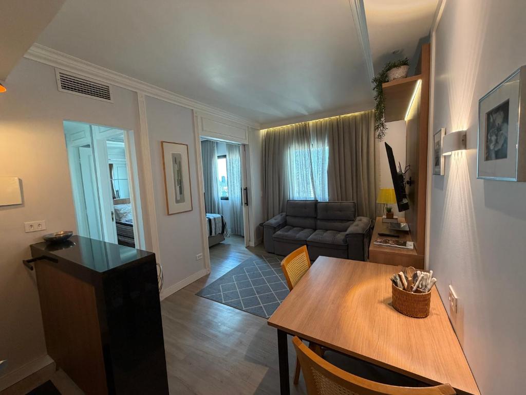 a living room with a table and a couch at Hotel Inter Jardins UH-2310 in São Paulo