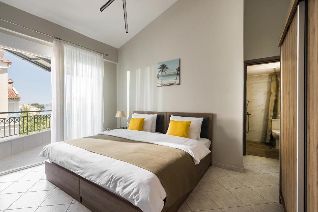 a bedroom with a large bed and a balcony at Sakis 2 in Polychrono